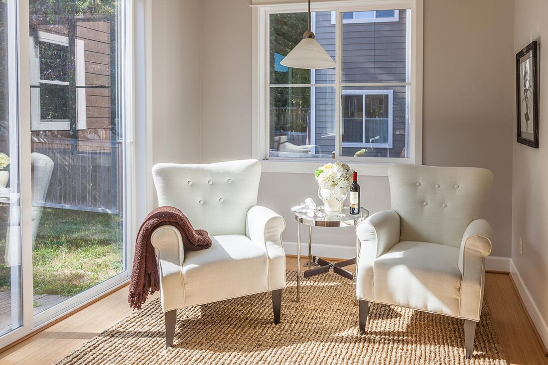 Staged den area with neutral white and cream colors.
